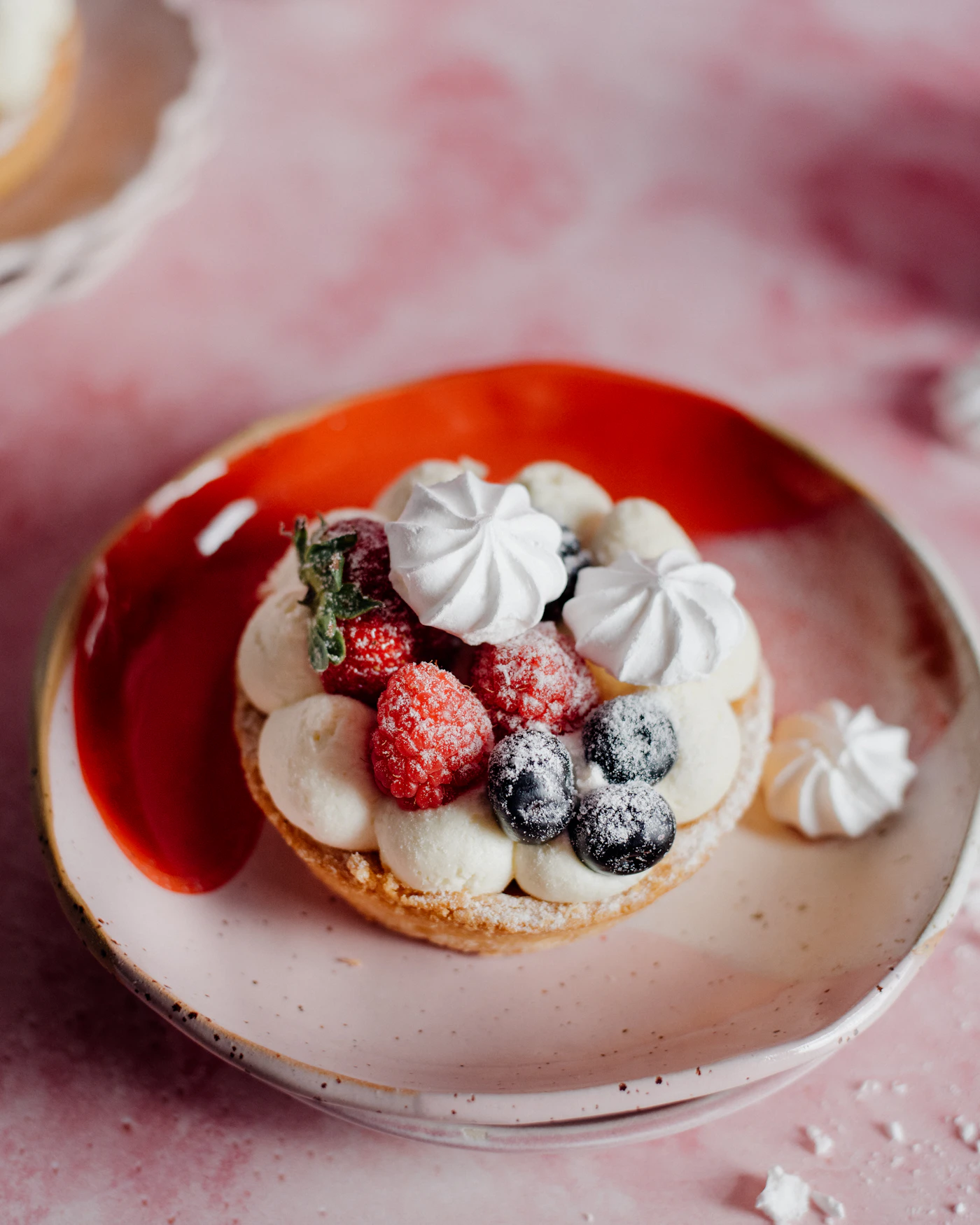 Mixed berry tart with vanilla cream on a purple background