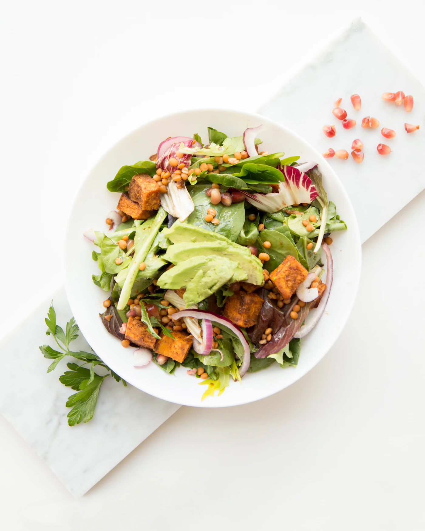 Colorful garden bowl with roasted beet, grains, cabbage and a soft egg on a purple background