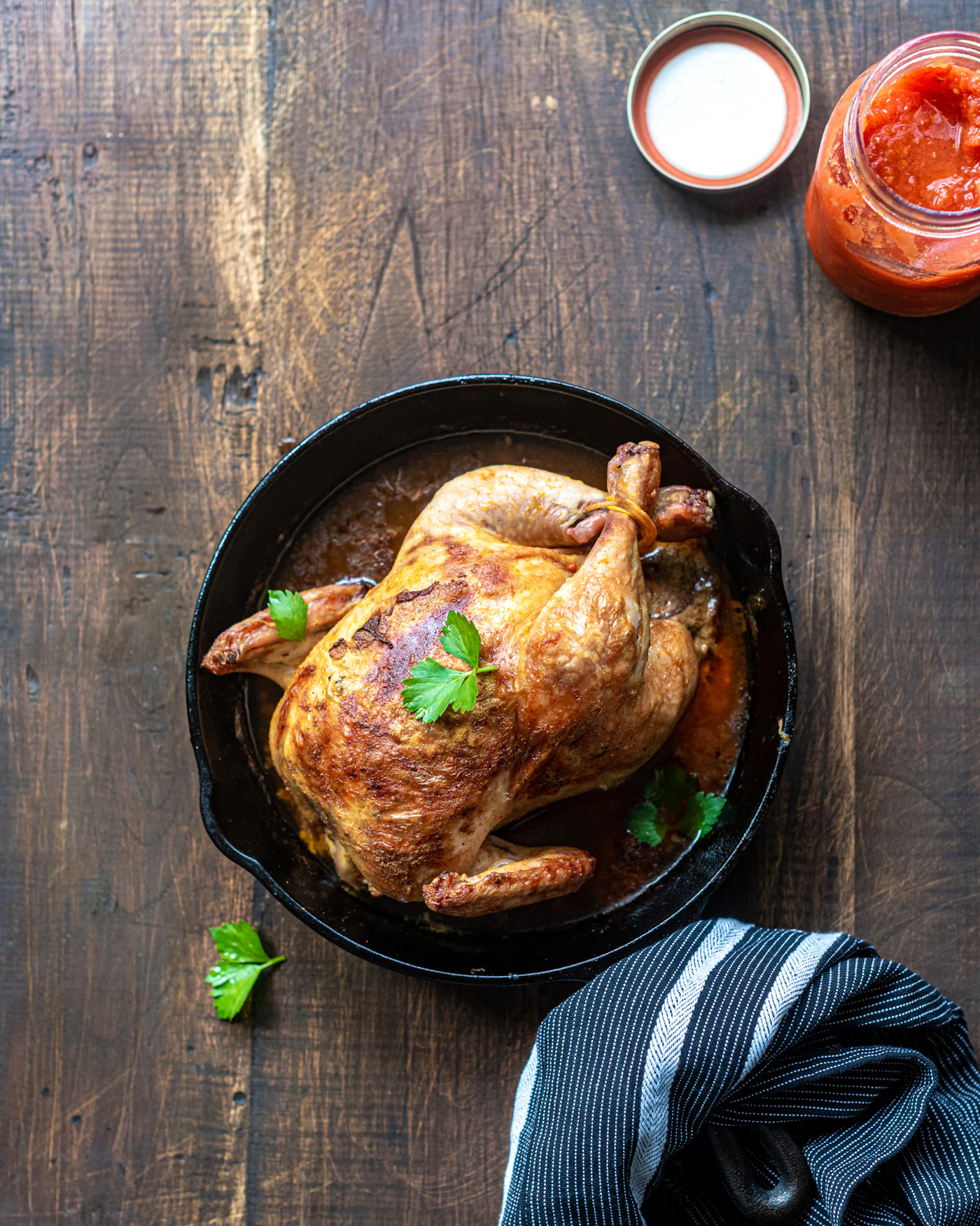Herb-roasted chicken pieces with charred citrus and purple cabbage on a green background