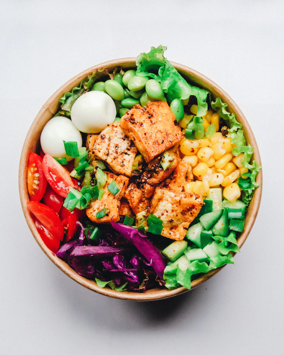 Seasonal grain bowl with citrus slices on an orange background, featured in the newsletter section